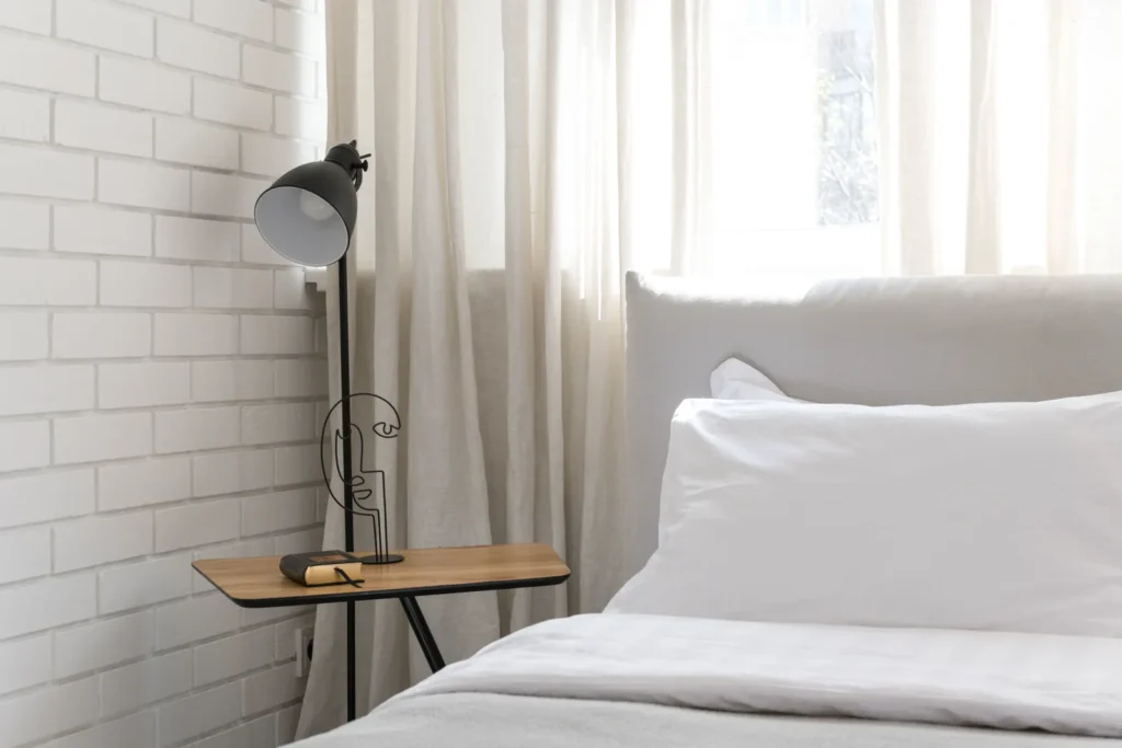 Bedroom with layered bedding and a bedside lamp for a comfortable sleep temperature