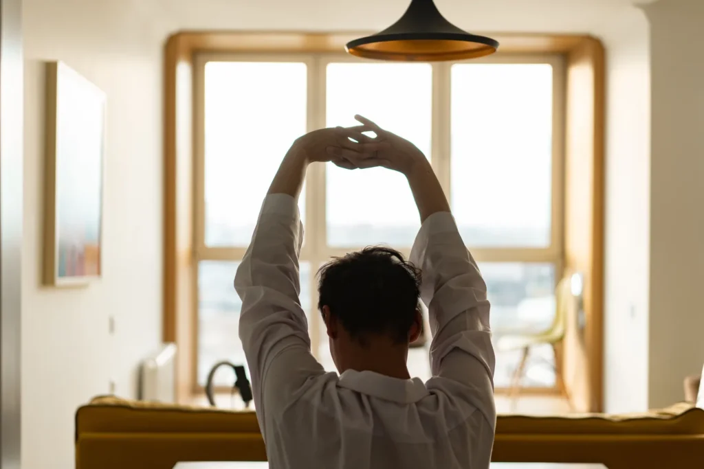 Man over 40 stretching at home after an evening workout before bed
