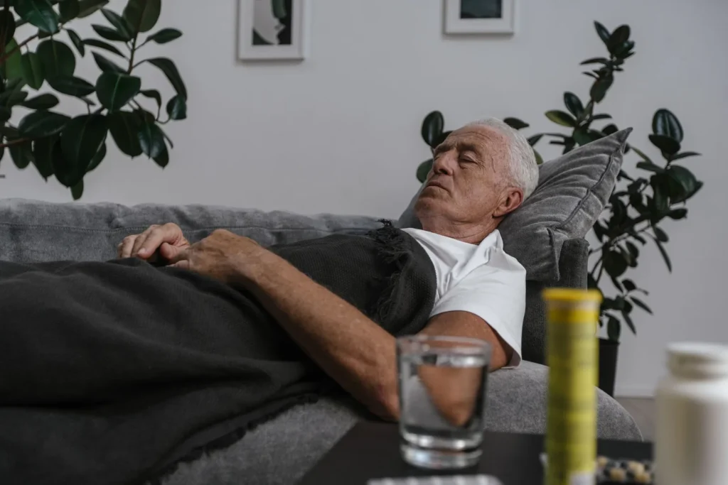 Man over 40 taking an early afternoon nap on a sofa